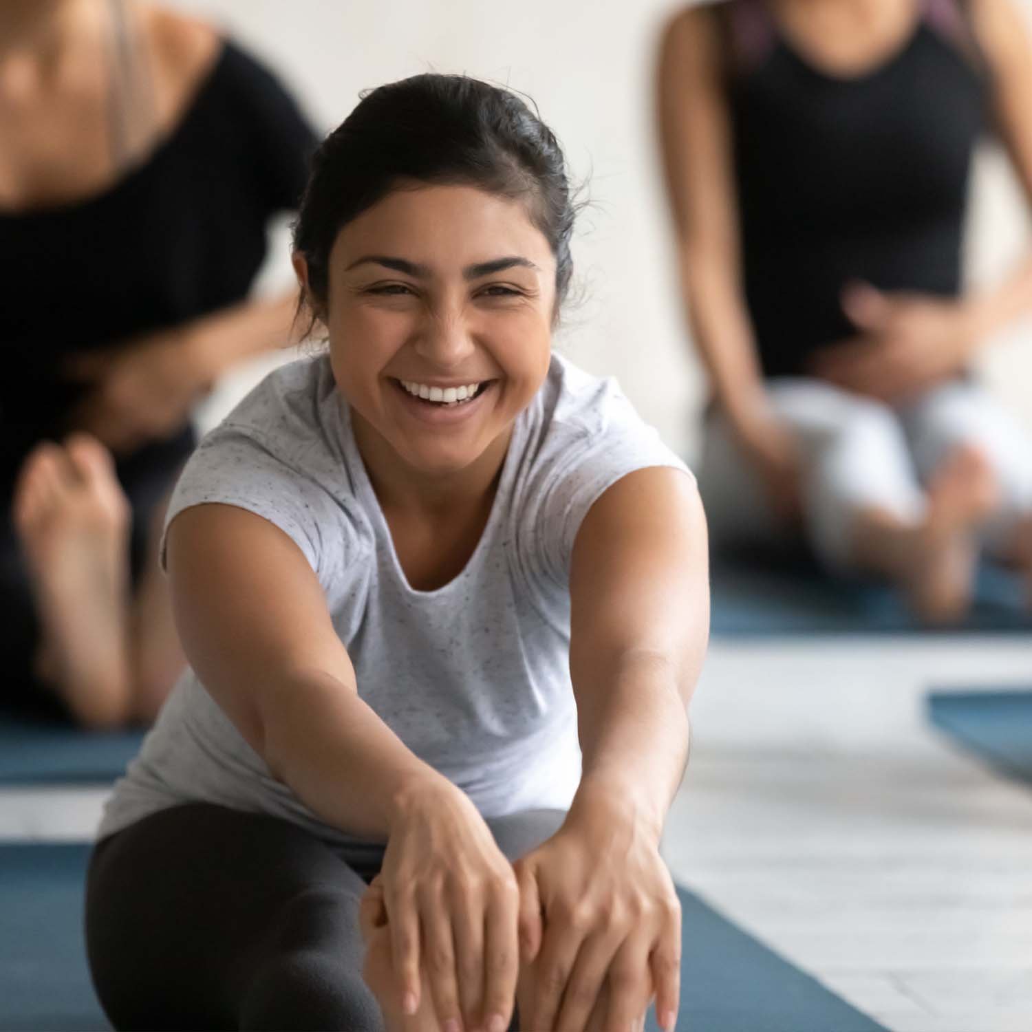 Smiling woman stretching in a yoga class