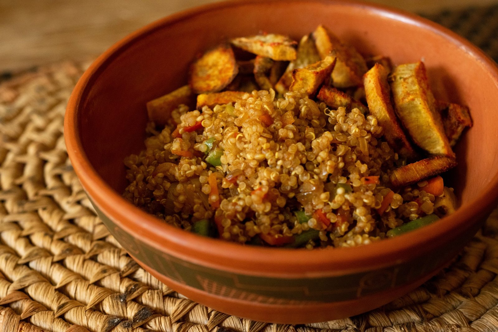 Quinoa bowl with roasted vegetables and fried plantains
