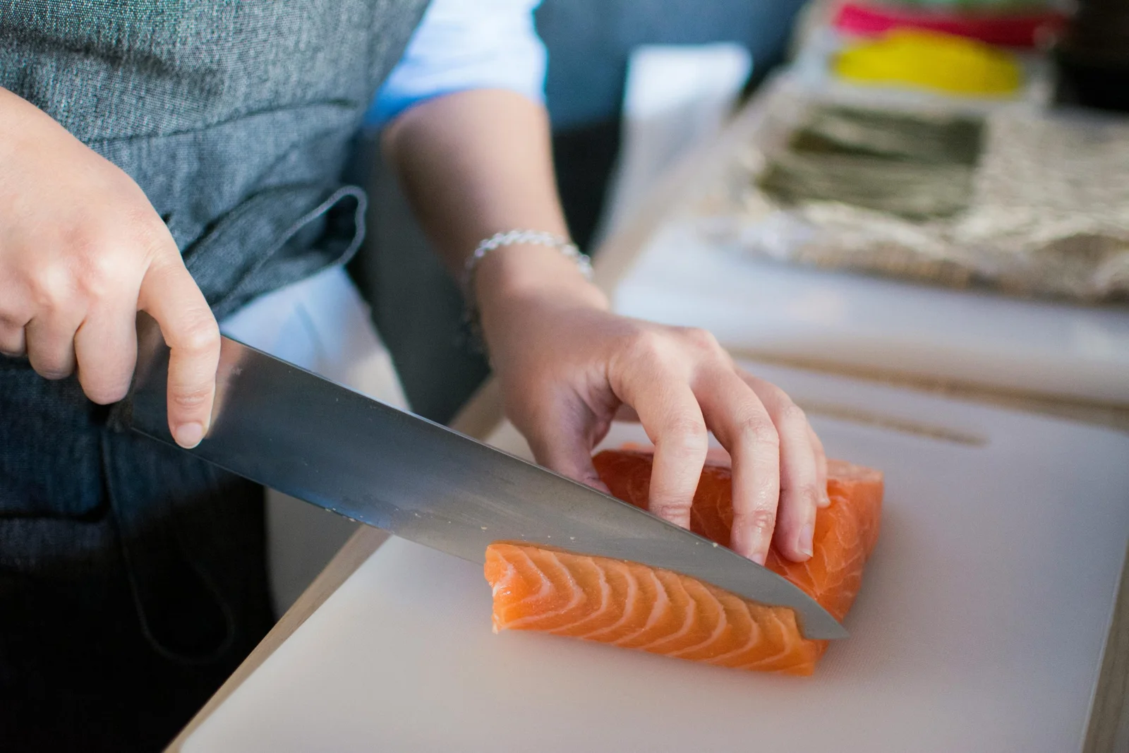 A person slicing a salmon fillet on a cutting board