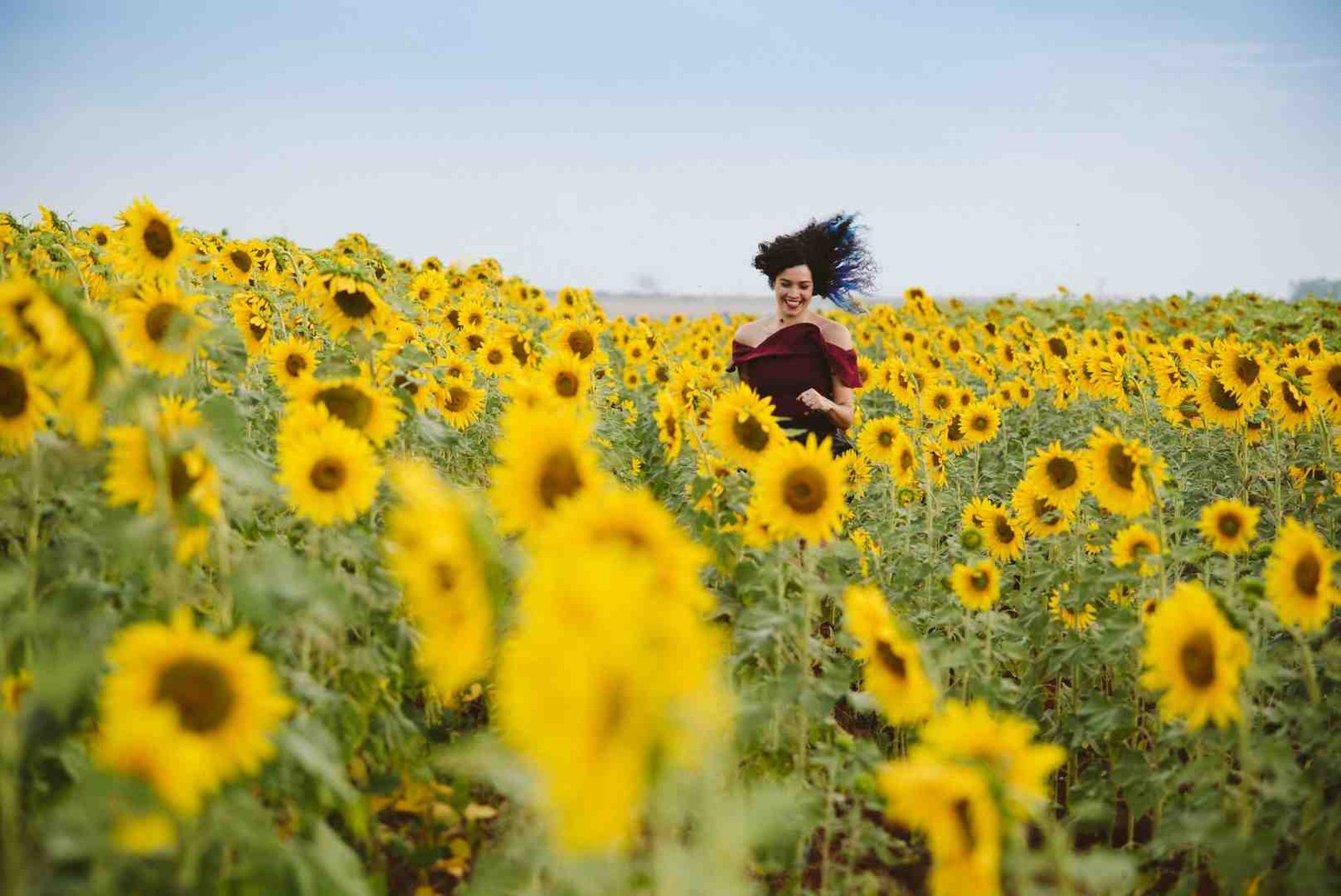 Woman running through a sunflower field